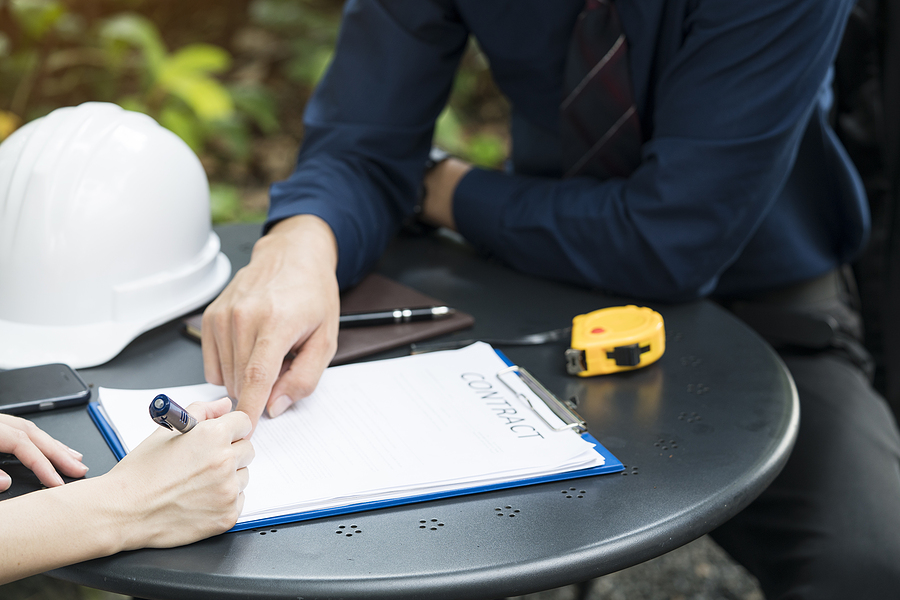 homeowner going over a detailed proposal and signing a contract homeowner going over a detailed proposal and signing a contract