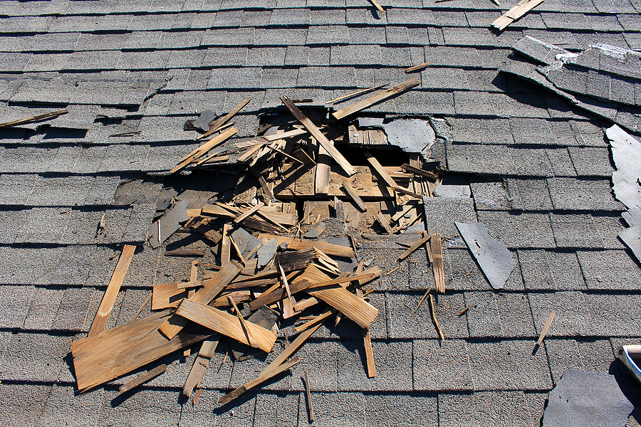 Roof construction site. Removal of old roof, replacement with ne View of brown two story house against blue sky with gables windows and clean roof.